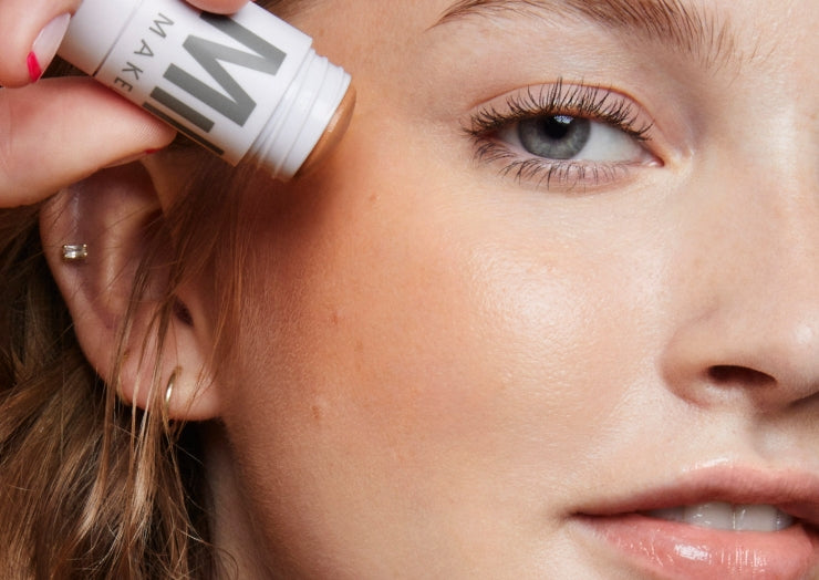 Close-up image of model applying Milk Makeup Matte Bronzer to cheeks against a white background